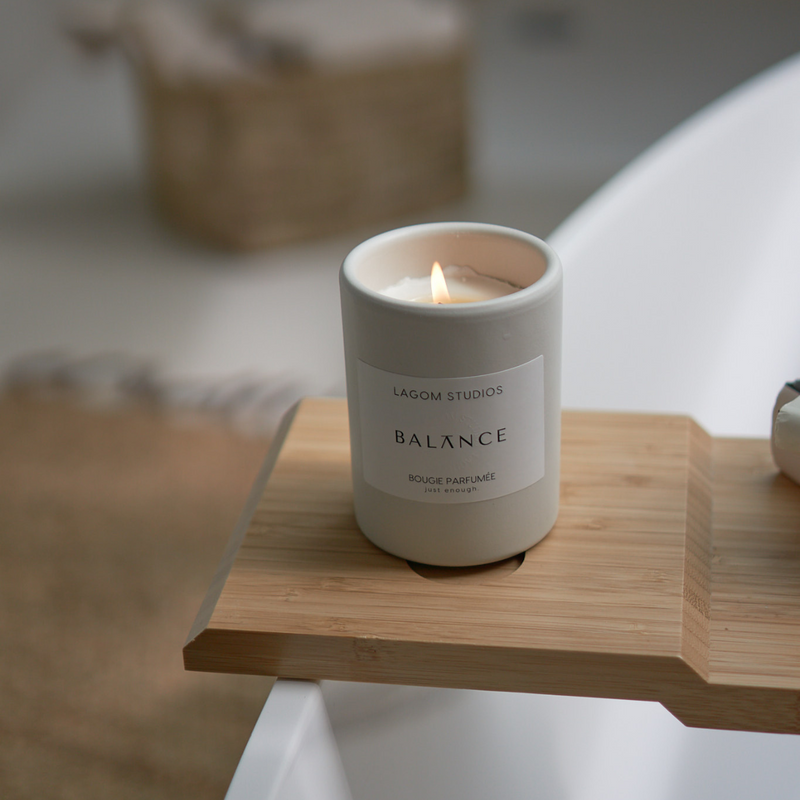 Lagom Studios_Vegane Duftkerze Balance in weißem Keramikgefäß auf Badewannenbrett im Badezimmer