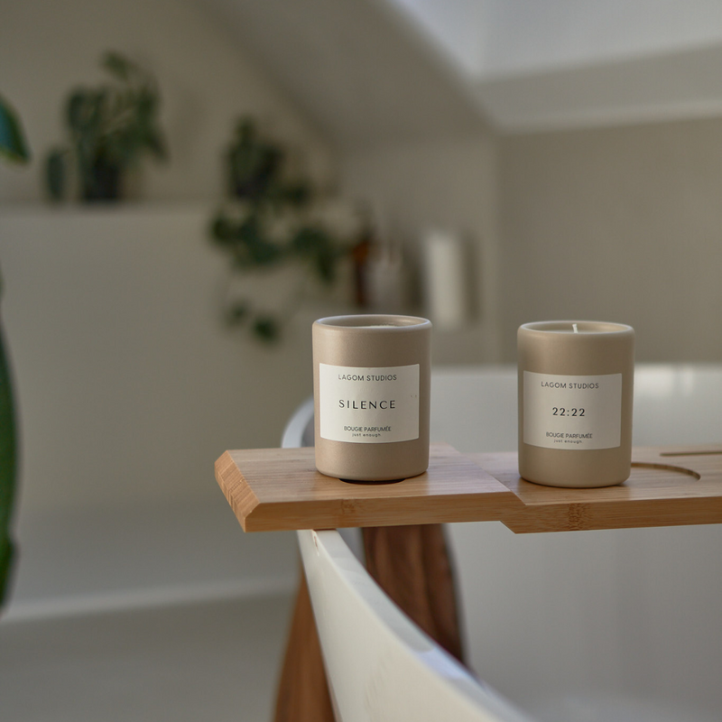 Lagom Studios_Vegane Duftkerzen in cremefarbenem Keramikgefäß auf Badewannenbrett im Badezimmer